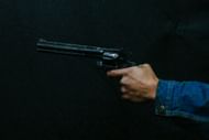 A representative image of a person holding a gun (Image via Unsplash/@@alejoreinoso)